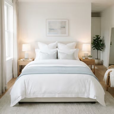 A freshly made bed with crisp white linens